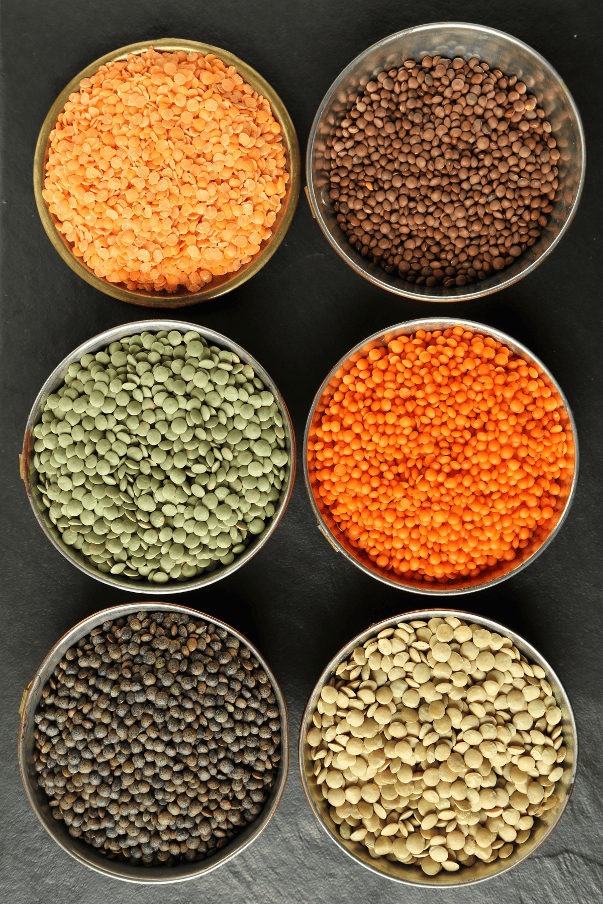 six types of lentils in different bowls.