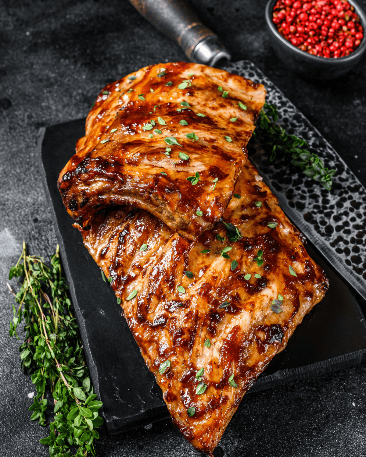 halved baked pork ribs grilled on the stovetop and served with herbs on top.