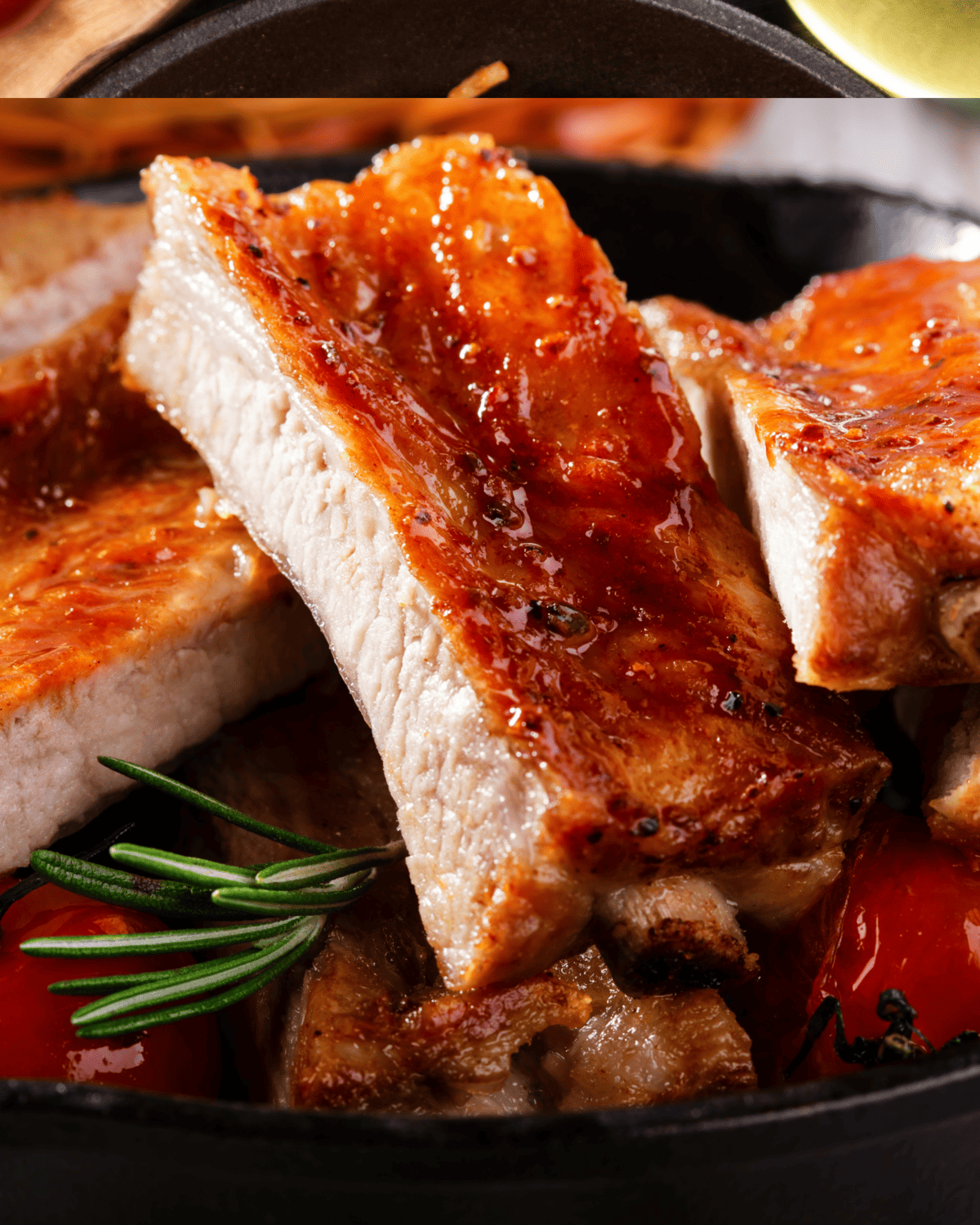 close up of one among several oven baked pork ribs served in a  skillet.