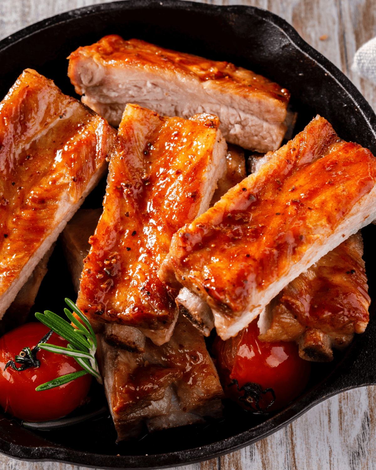 oven baked pork ribs brushed with honey, sliced, and served in a skillet.