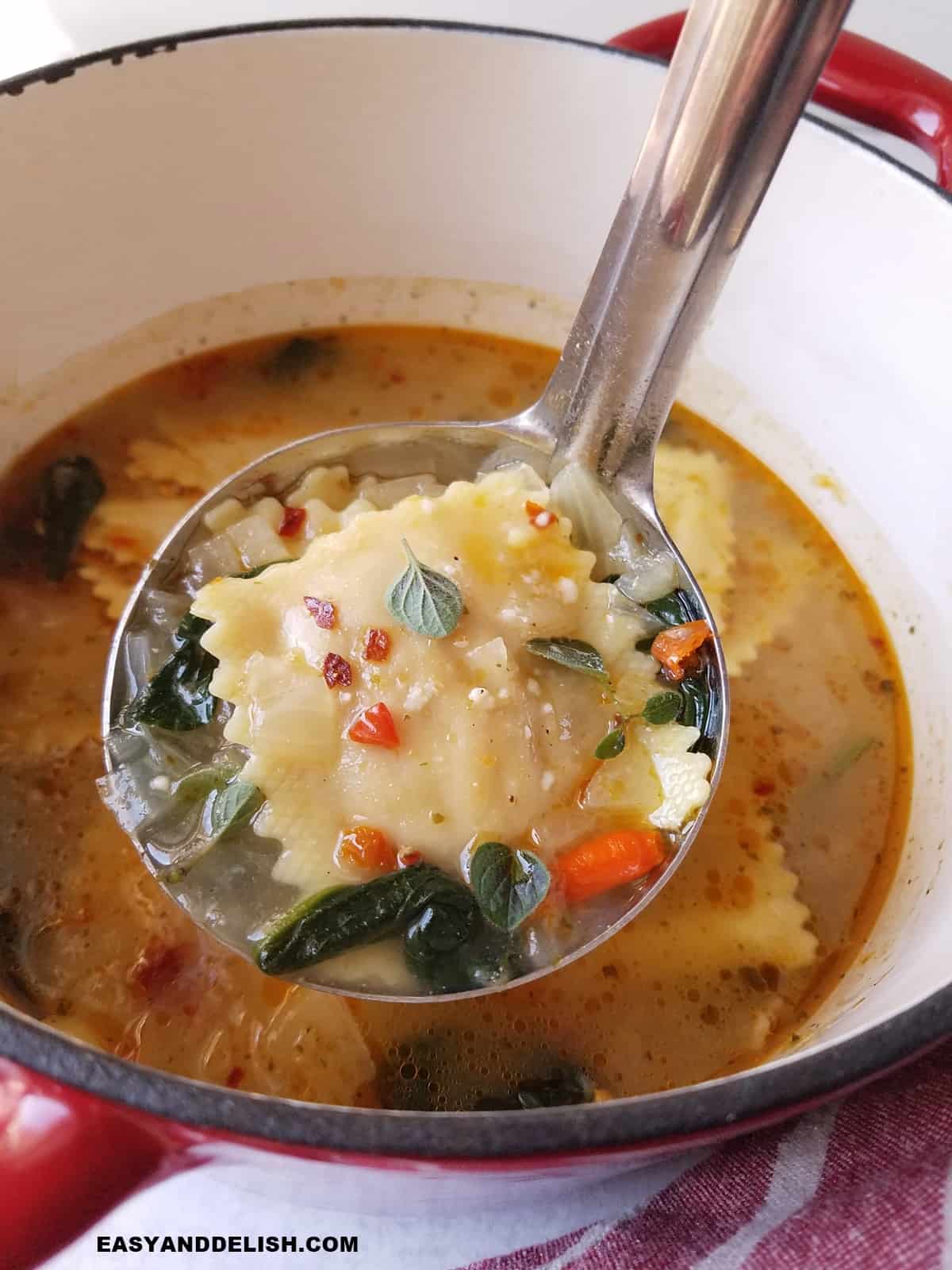 a ladle of hot ravioli soup held over a pot.