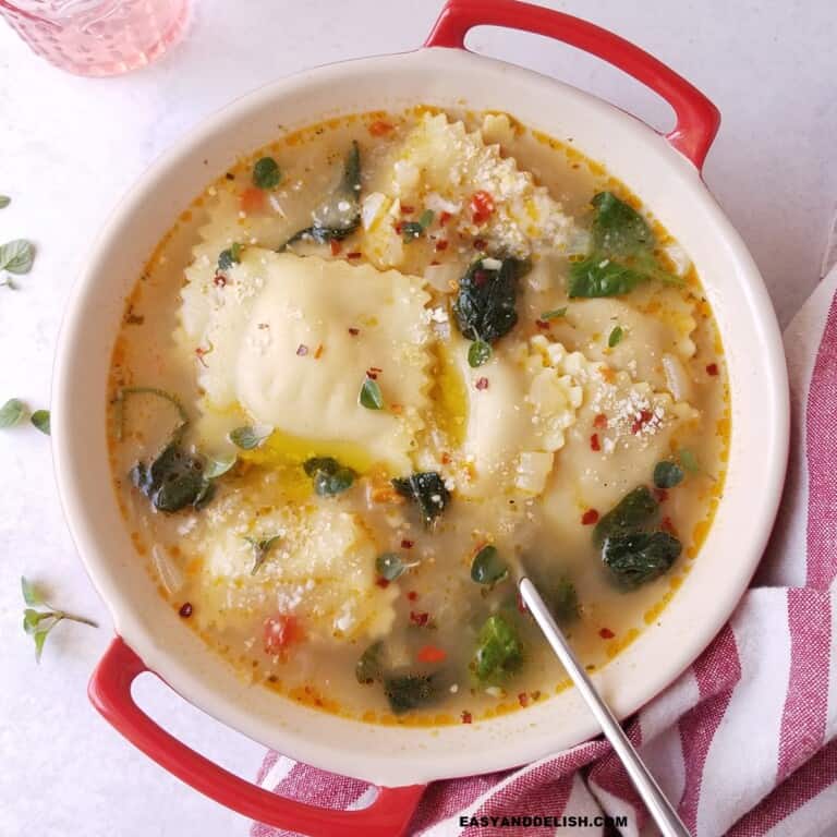 ravioli soup in a bowl with a spoon on the side.