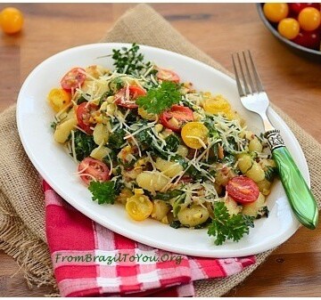 Gnocchi com Couve, Toucinho, Milho, e Tomate em um prato branco com um garfo verde