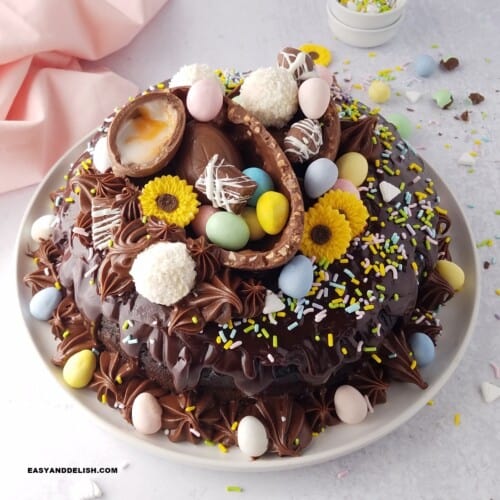 close up of an Easter bundt cake amde with sour cream and chocolate, topped with chocolate ganache, and decorated with Easter eggs.