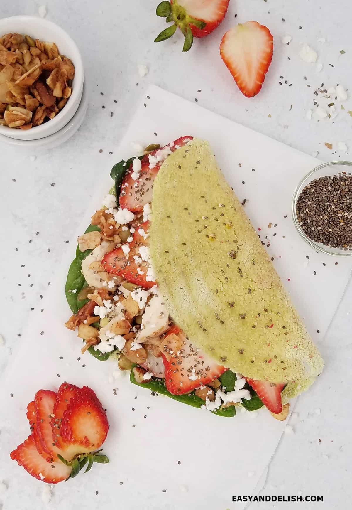 Green tapioca crepe filled with a spinach and strawberry salad.