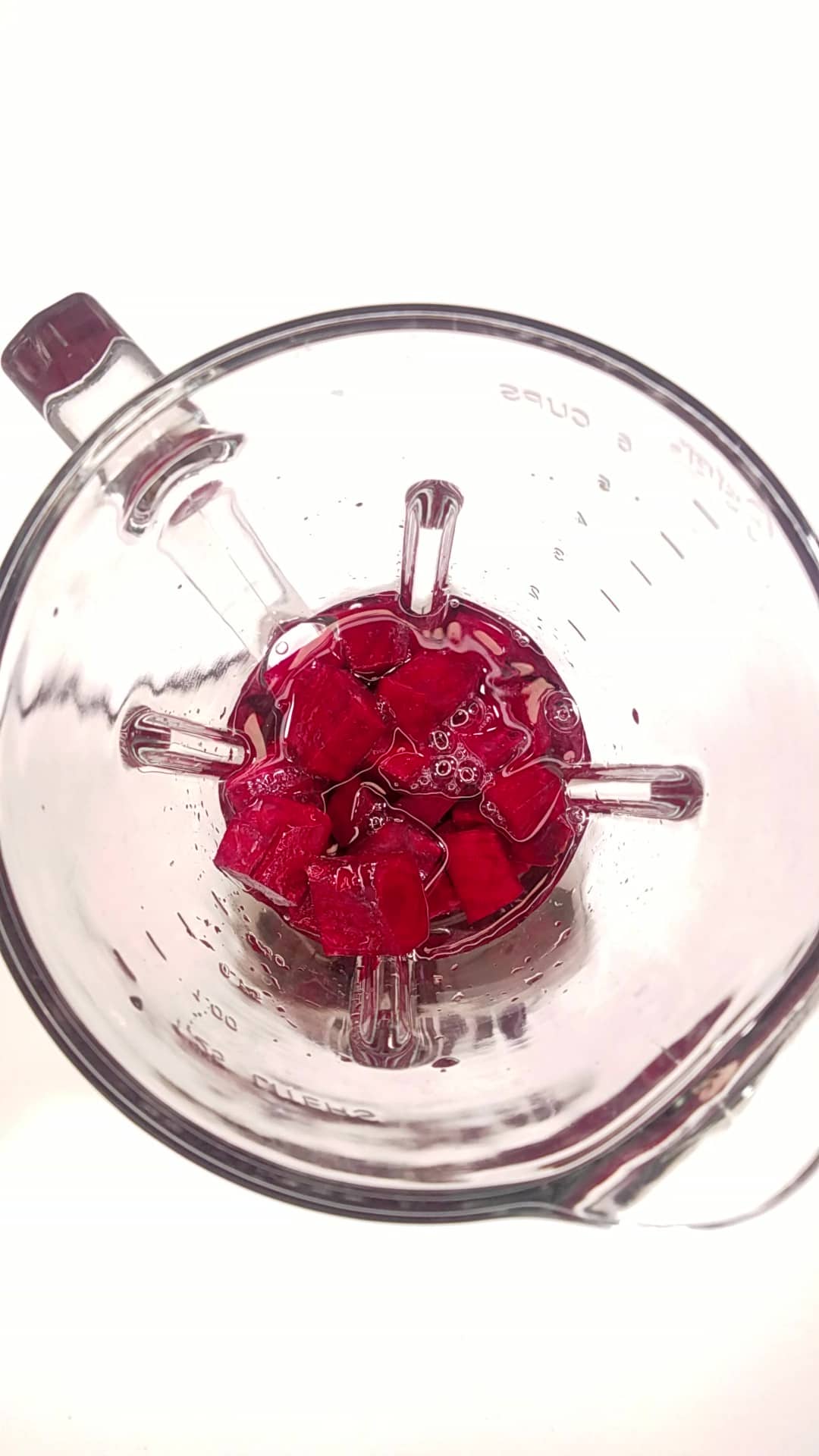 Blending chopped beets and water in a blender.