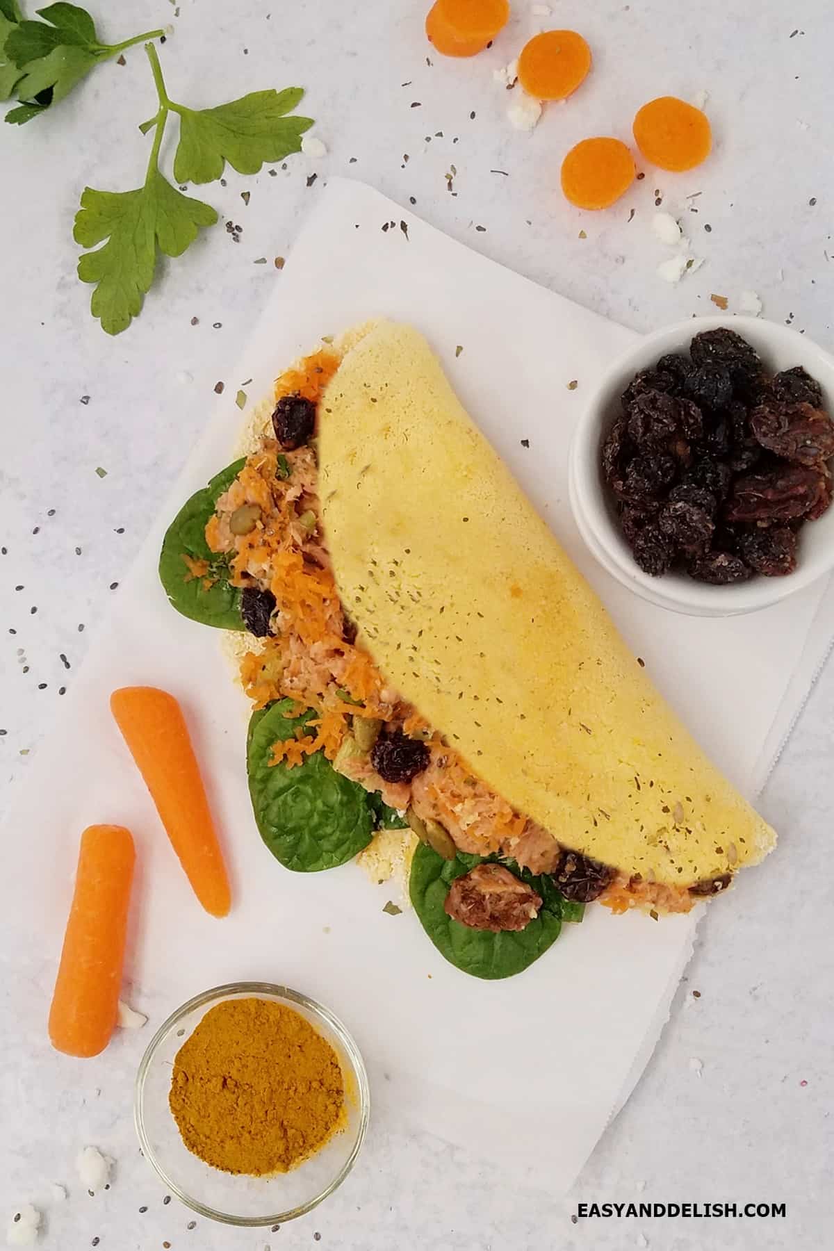 yellow tapioca crepe filled with tuna salad with a few carrots on the side.