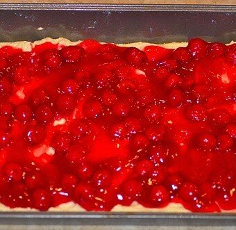 cherry pie filling spread out on the batter