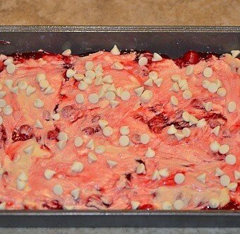 dough and chocolate chips distributed on top of the cherry pie topping