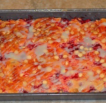 white chocolate cherry pie bars drizzled with glaze in a pan