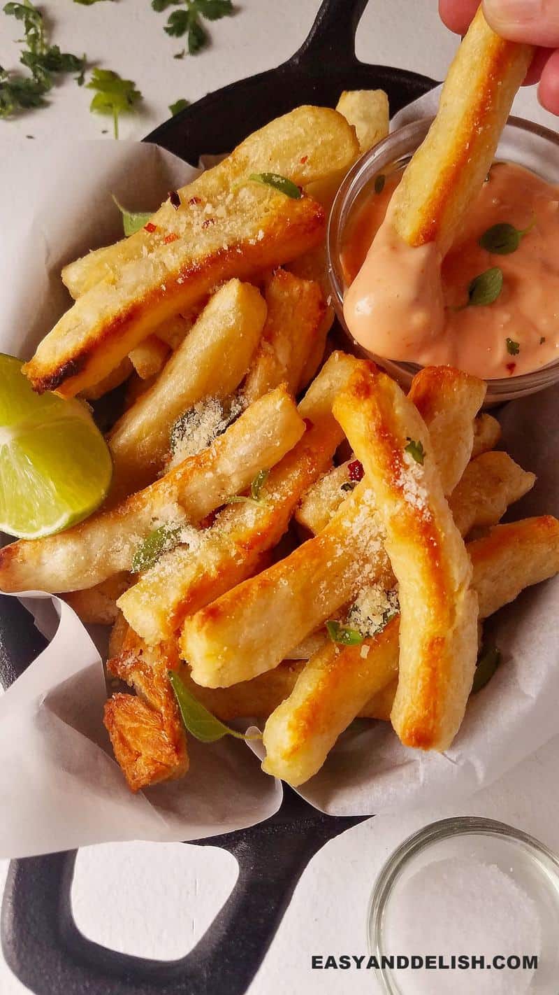 yuca fires in a bowl with lime and a sauce