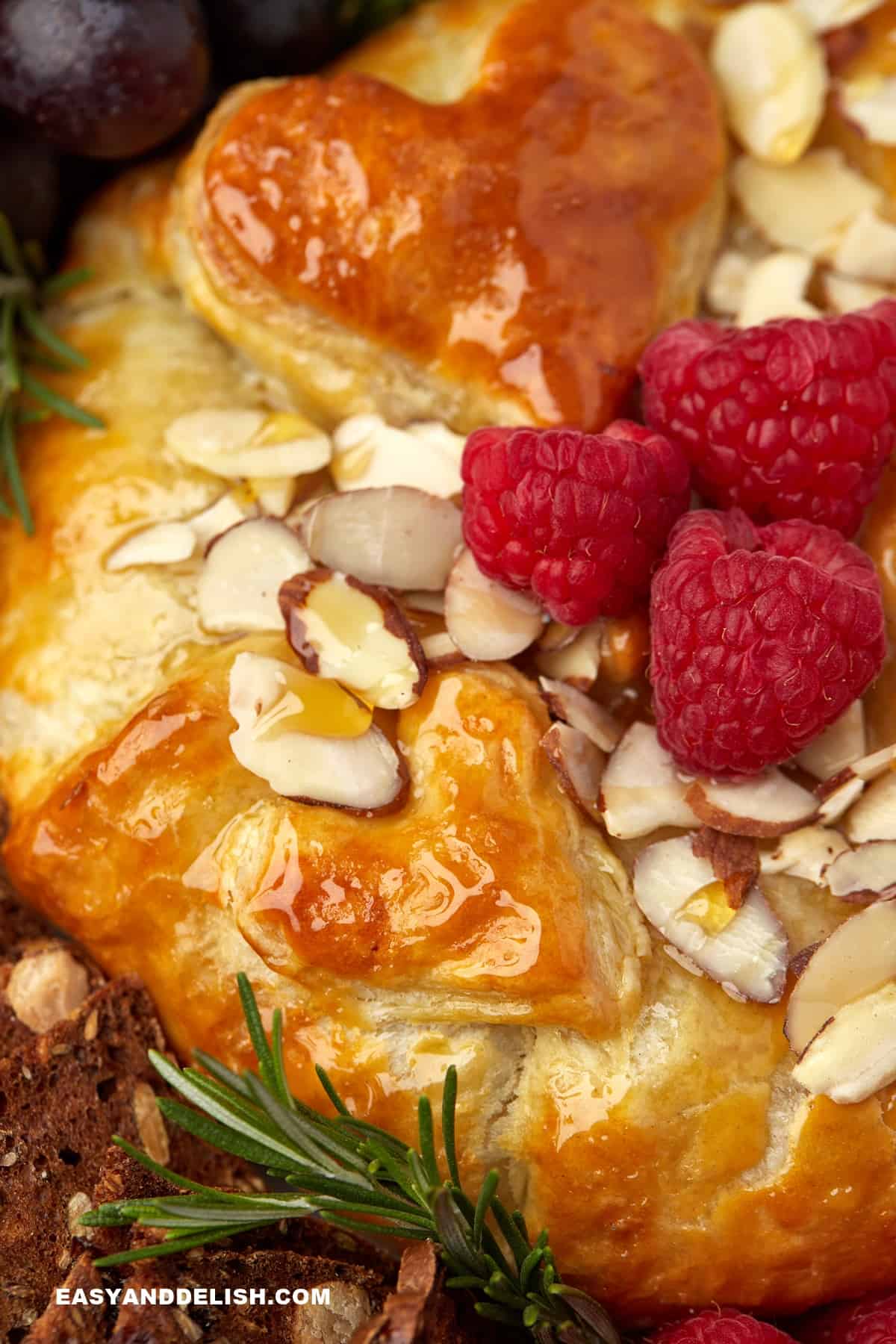 Close up of half wheel of baked briw en croute with jam and honey.