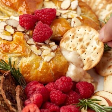 a cracker dipped in baked brie en croute.