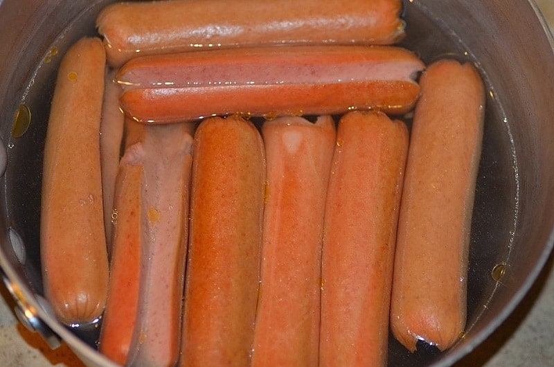 A bunch of hot dogs cooking 