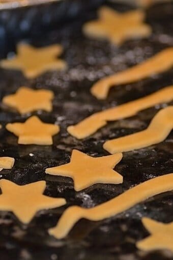 Pie dough cut into the shapes of stars and stripes resting on a floured surface