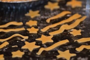 Pie dough cut into the shapes of stars and stripes resting on a floured surface
