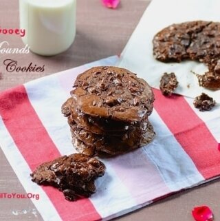A stack of double chocolate cookies with a glass of milk