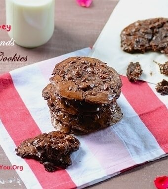 A stack of double chocolate cookies with a glass of milk