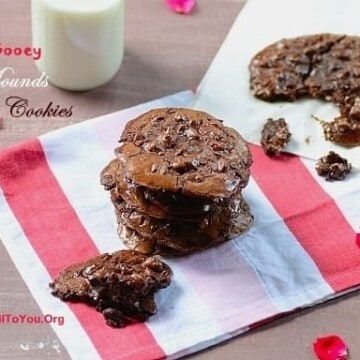 A stack of double chocolate cookies with a glass of milk