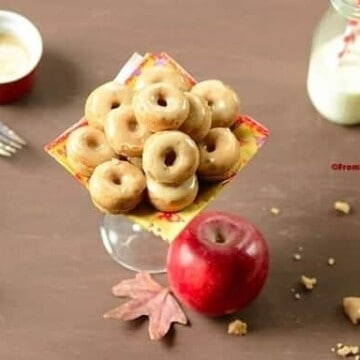 mini baked donuts in a platter with an apple on the side