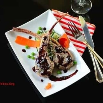 A plate of lamb chops with garnishes