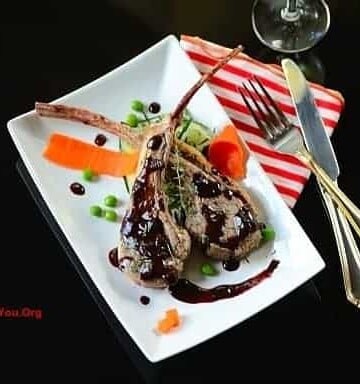 A plate of lamb chops with garnishes