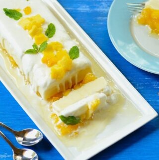 A plate of frozen pineapple trifle with spoons of the side