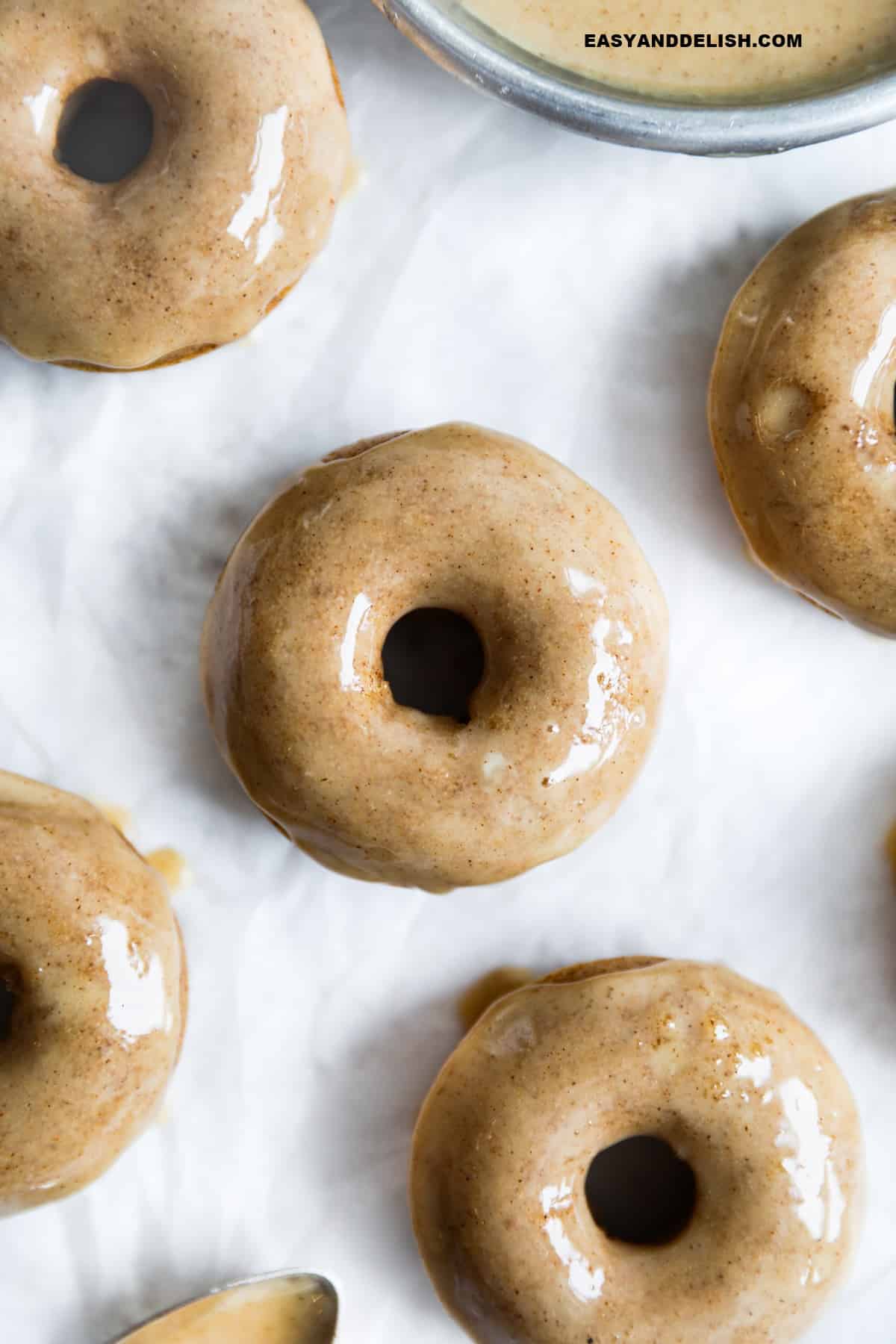 several glazed apple cider baked donuts on a surface