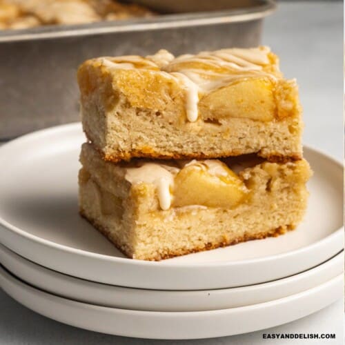 close up of two apple bars piled up topped with vanilla glaze.