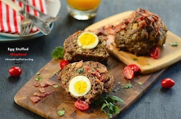 Meatloaf stuffed with boiled egg on a wood serving board