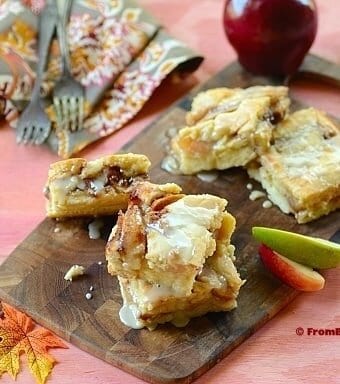 slices of apple cobbler bars on a platter with garnishes on the sides