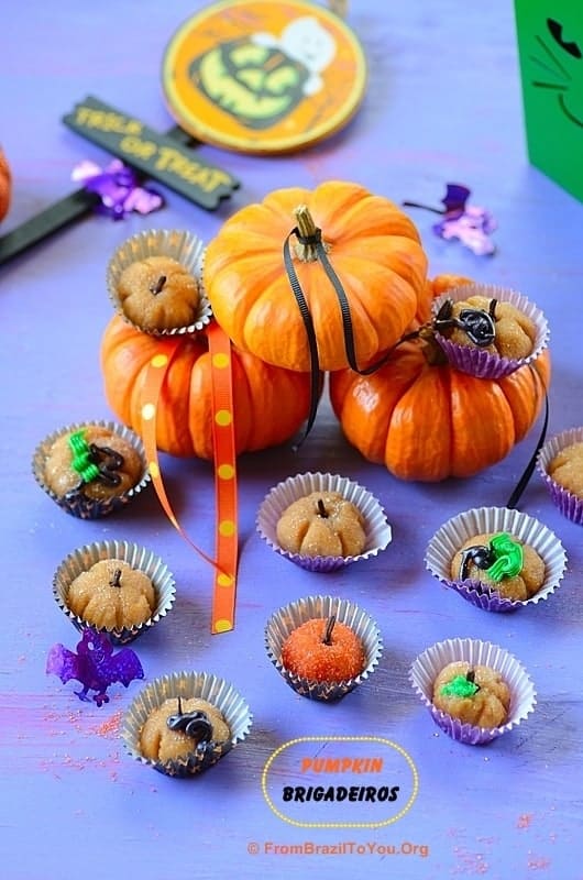 Pumpkin Brigadeiros displayed on a table with mini pumpkin behind