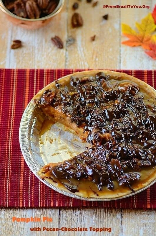 Pumpkin Pie partially sliced with nuts on the background 