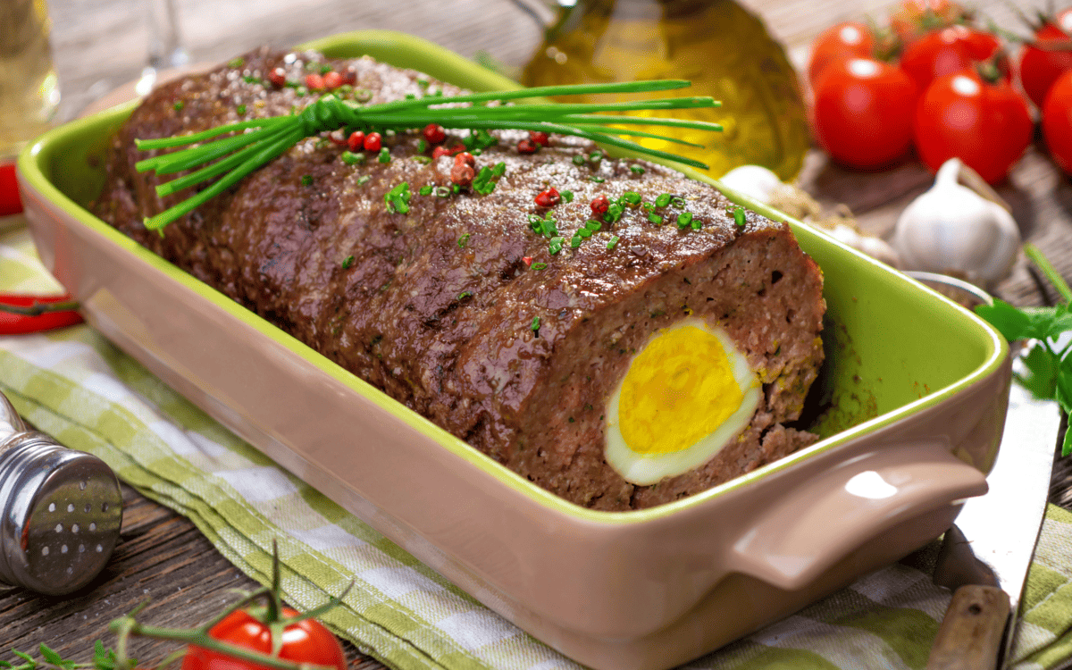 meatloaf with boiled eggs topped with garnishes.
