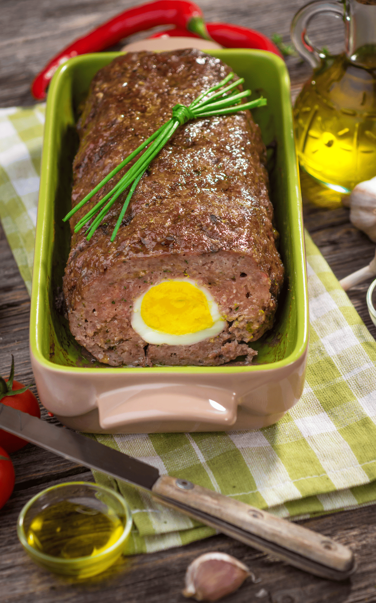 ground beef loaf in a baking dish topped with fresh herbs.
