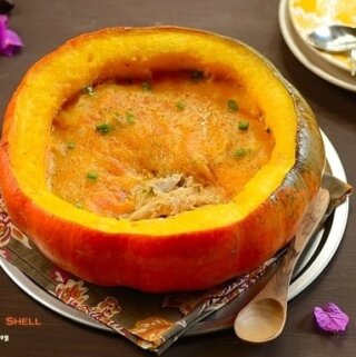 A half pumpkin shell filled with chicken stew topped with melted cheese