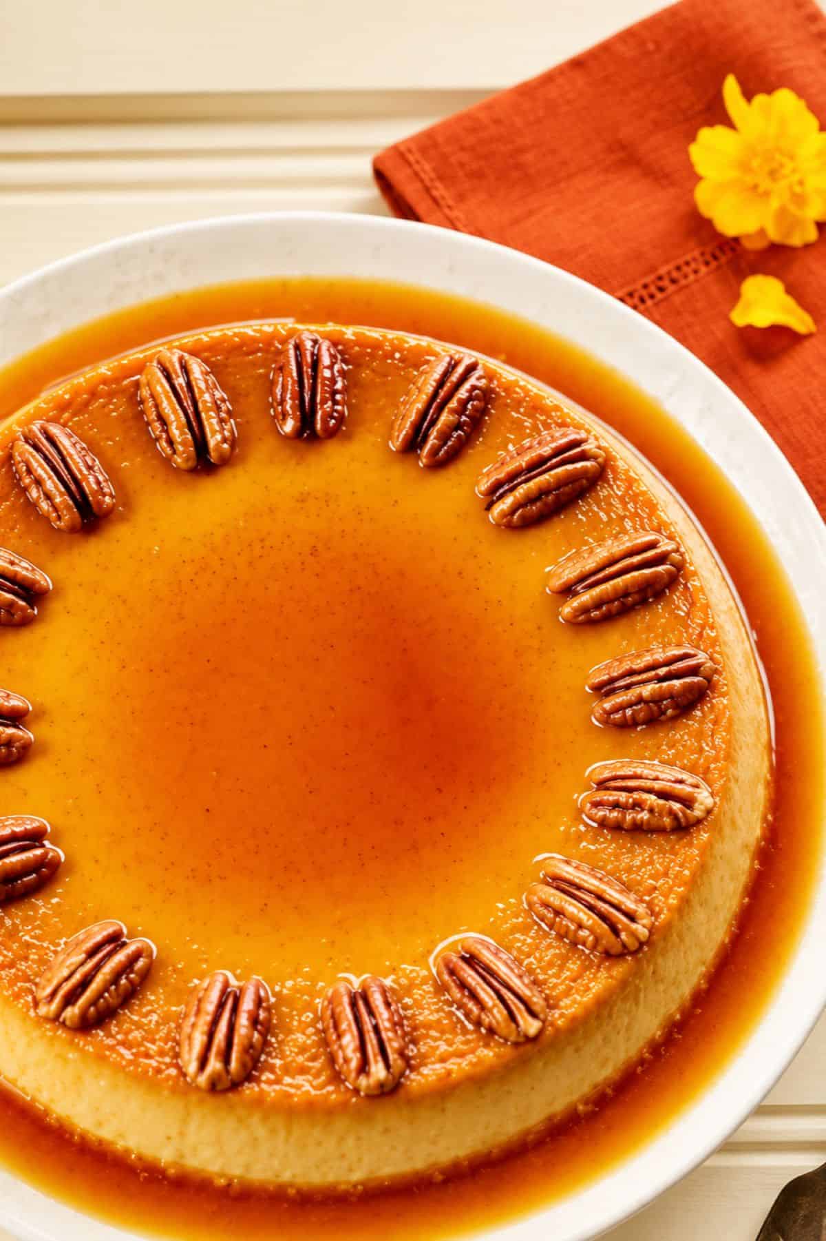 Pumpkin pie flan with caramel sauce and toasted pecans.