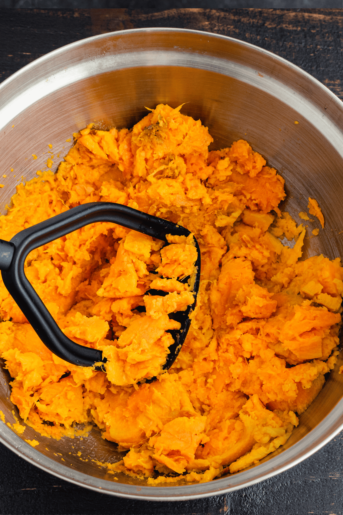 Cooked root vegetable mashed with a potato masher. 