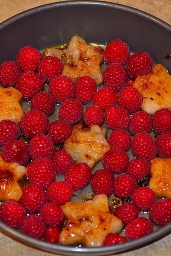 star shaped sauteed pears and raspberries in a buttered pan