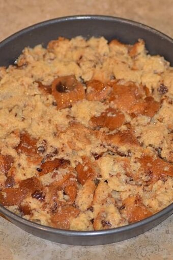 panettone cubes spread out in a dish over the layered fruits