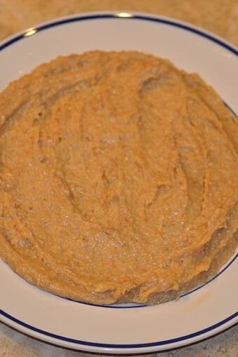 dough mixture spread out on a greased white plate to cool