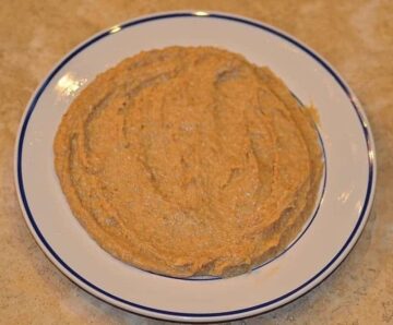 dough mixture spread out on a greased white plate to cool