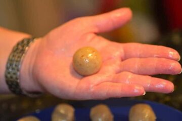 A round ball of dough held in the palm of a hand