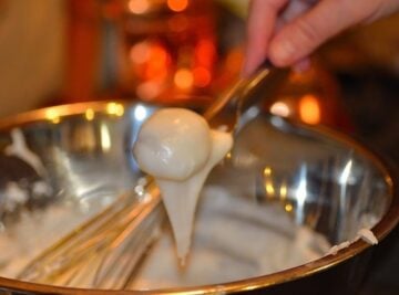 camaféu de nozes being dipped in the fondant glaze with a fork