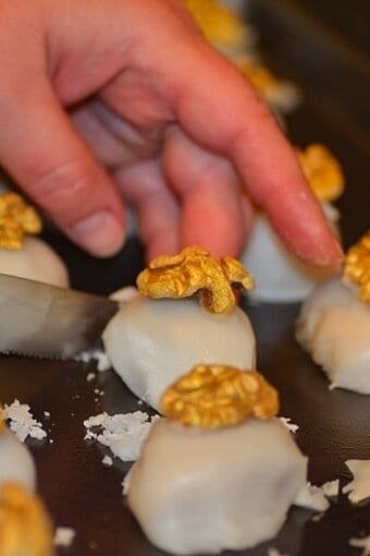 excess glaze being trimmed off the walnut cameos with a knife