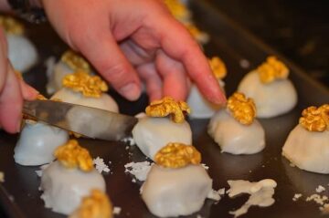 excess glaze being trimmed off the walnut cameos with a knife
