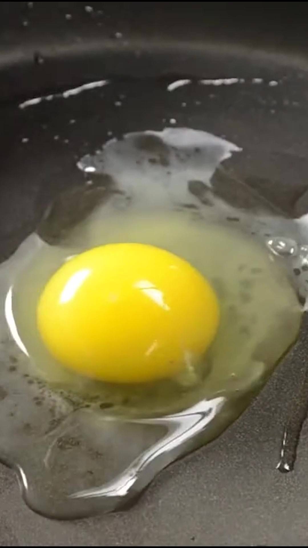 Egg cracked onto a non-stick greased skillet.