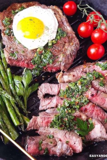 A skillet with steak and eggs plus vegetables (close up)