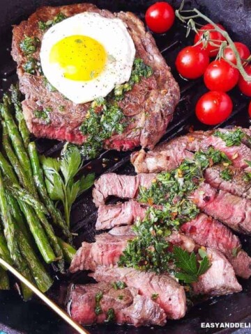 A skillet with steak and eggs plus vegetables (close up)