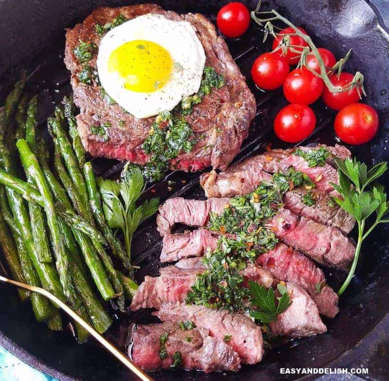 A skillet with steak and eggs plus vegetables (close up)